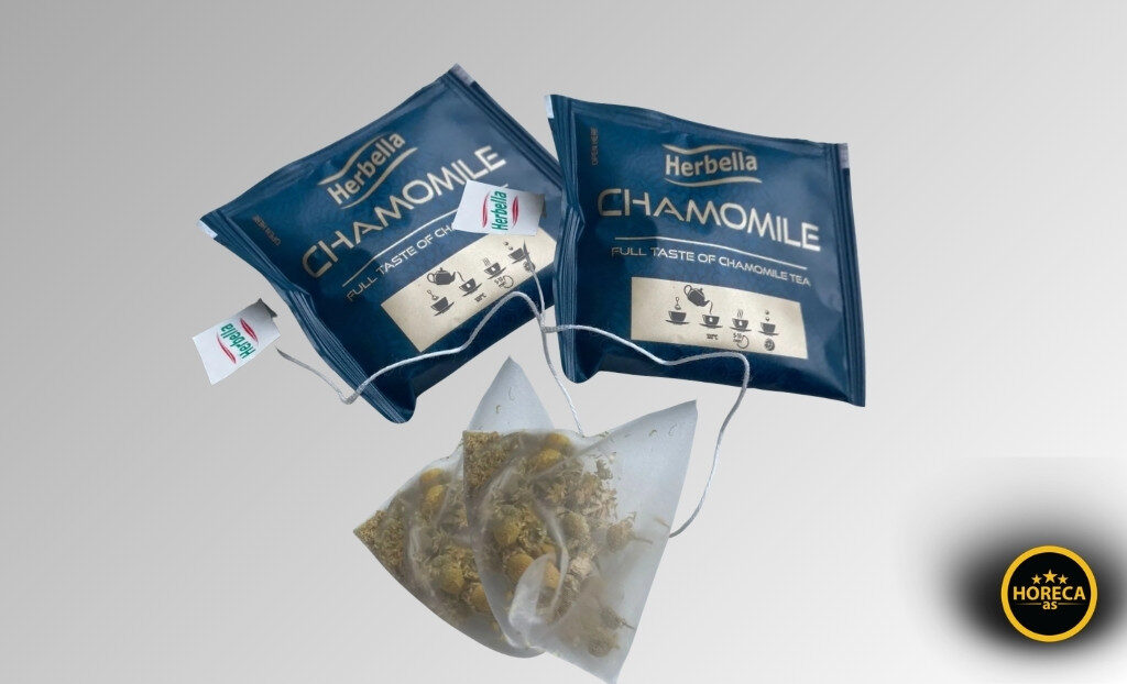 Dve kesice premium čaja od kamilice sa vidljivim sadržajem i koncem na svetloj pozadini