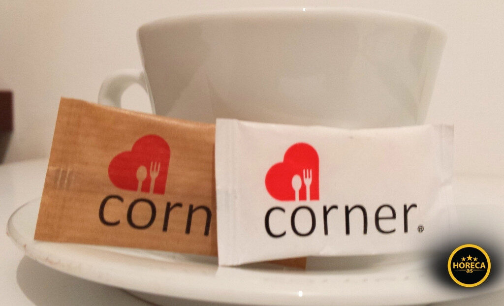 Šećerići u kesicama sa logom firme pored šoljice kafe