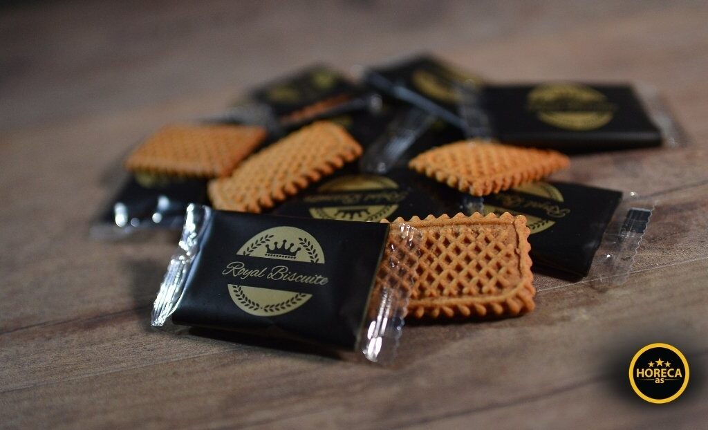 Speculaas keks u pojedinačnom pakovanju pored nekoliko raspakovanih keksića na stolu