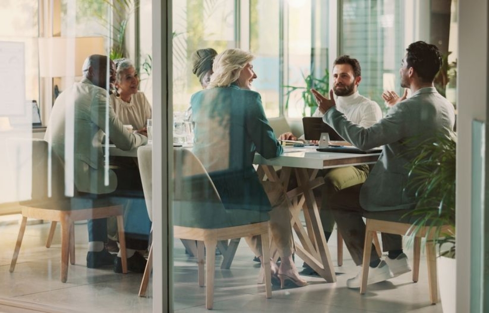 Tim ljudi na poslovnom sastanku u modernoj kancelariji sa staklenim zidovima