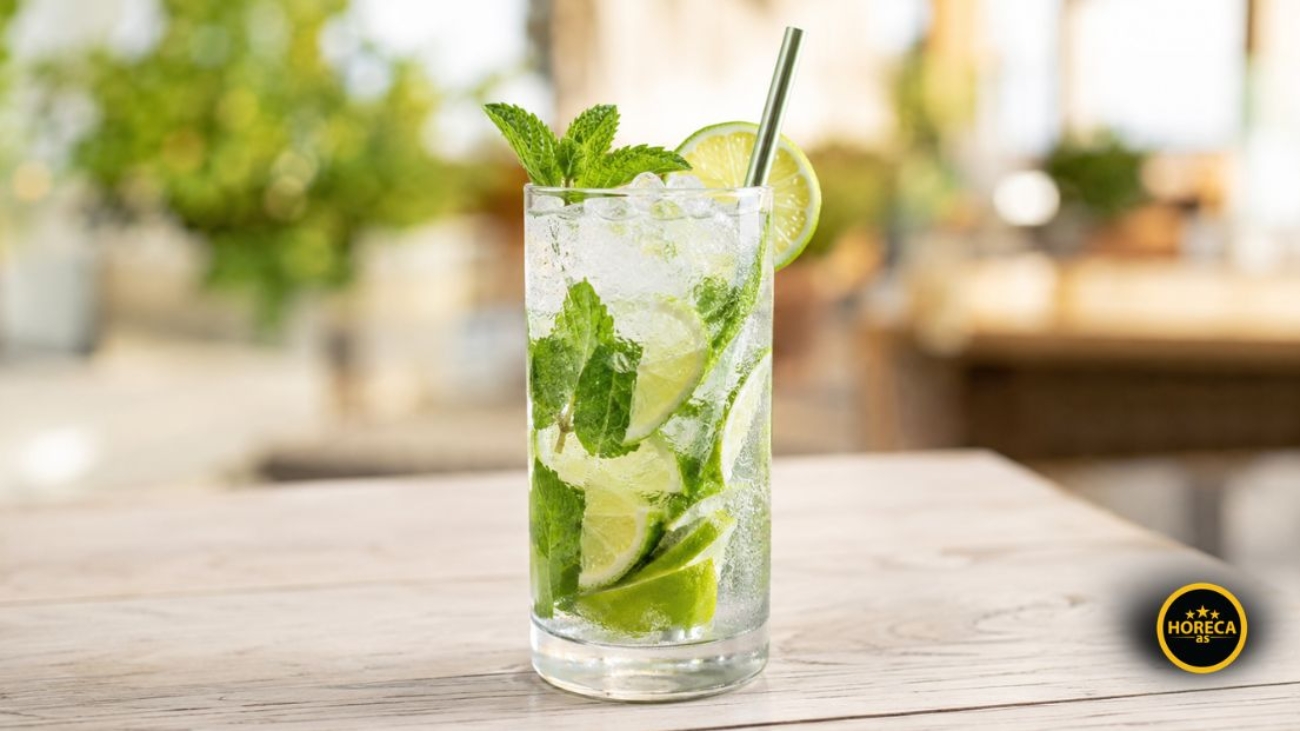 Mojito koktel sa ledom, kriškama limete i svežom mentom u visokoj čaši.