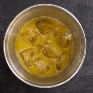 Pogled odozgo na Mai Tai koktel sa kockama leda u metalnom šejkeru.