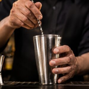 Barmen meša sastojke za Daiquiri u metalnom šejkeru uz barsku mericu